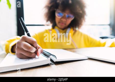 Girl writing in diary sitting in cafe Stock Photo