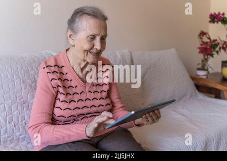 Senior woman using tablet PC at home Stock Photo