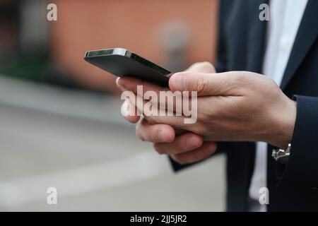 Hands of businessman using smart phone Stock Photo