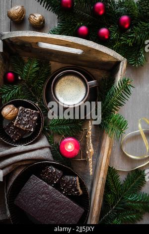 Tray with cup of coffee, twigs, burning candle and gingerbread Stock Photo