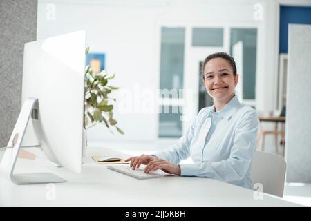 Happy businesswoman with computer on desk at office Stock Photo