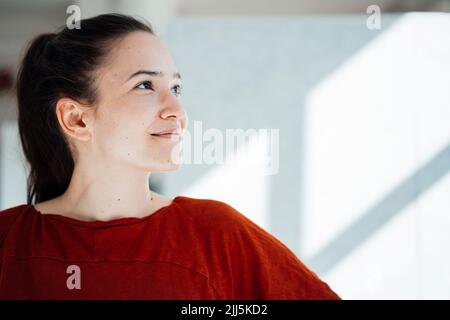 Thoughtful smiling young woman looking away Stock Photo