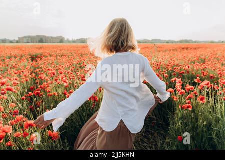 Woman dancing in poppy field Stock Photo