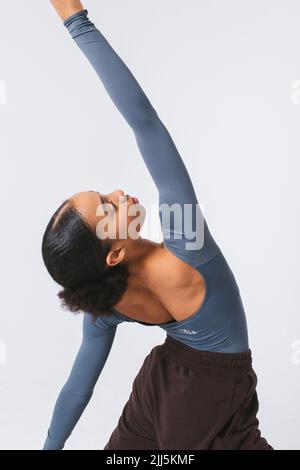 Ballet dancer with hand raised dancing against white background Stock Photo