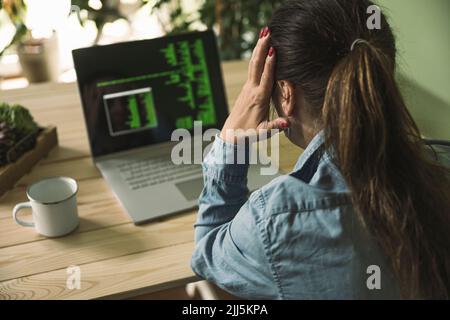 Tired businesswoman sitting in front of laptop at home office Stock Photo