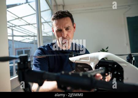 Mature technician analyzing drone at office Stock Photo
