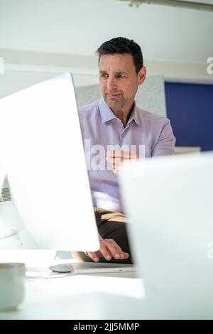 Businessman working on desktop PC at office Stock Photo