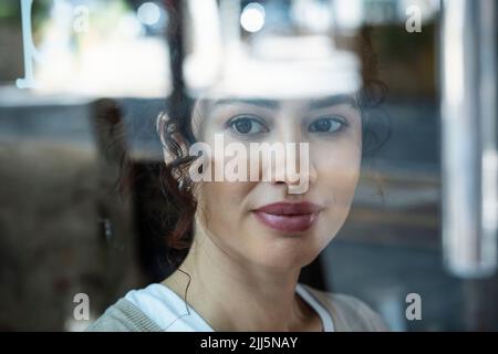 Beautiful woman seen through glass window Stock Photo