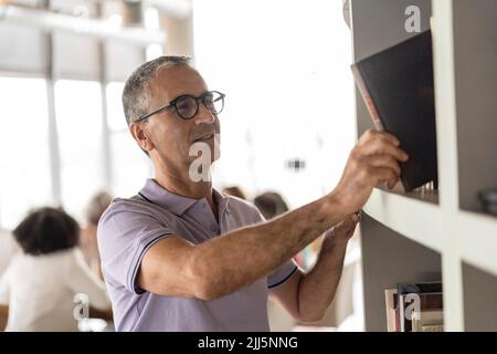 Businessman stacking file in rack at office Stock Photo