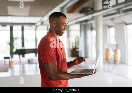 Working man using laptop standing at office Stock Photo