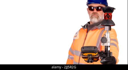 A builder in a blue helmet, orange reflective hi-visibility fleece and safety gloves on white background with space for text using modern surveying eq Stock Photo