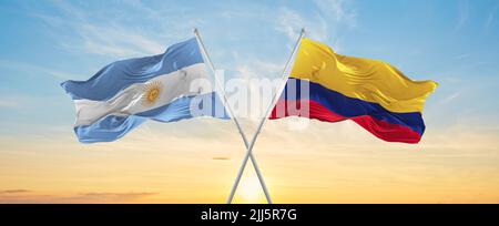 crossed national flags of Argentine and Colombia flag waving in wind at cloudy sky. Symbolizing relationship, dialog, travelling between two countries Stock Photo