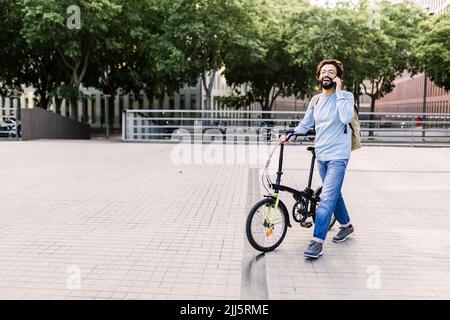 Man talking on phone walking in park Stock Photo