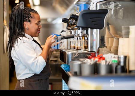 Smiling barista making coffee at restaurant kitchen Stock Photo