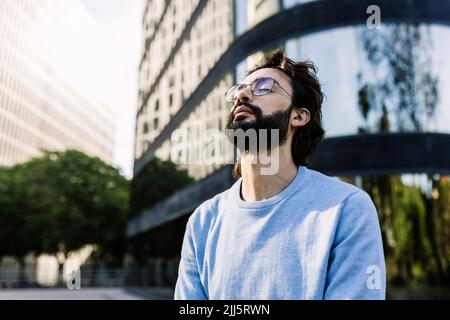 Bearded man with eyes closed in city Stock Photo