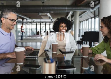 Happy business colleagues sitting together at desk Stock Photo