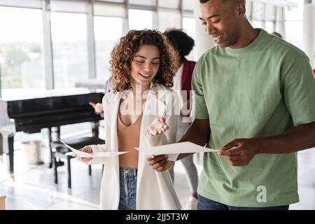 Happy businesswoman discussing over document with businessman Stock Photo