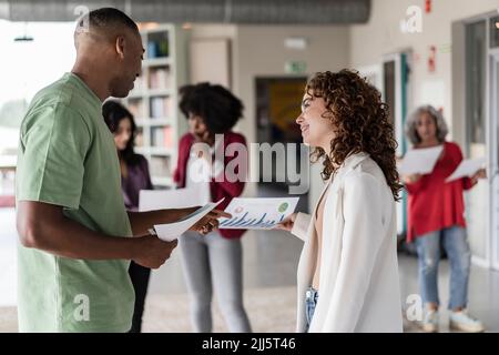 Happy businesswoman with document discussing at office Stock Photo