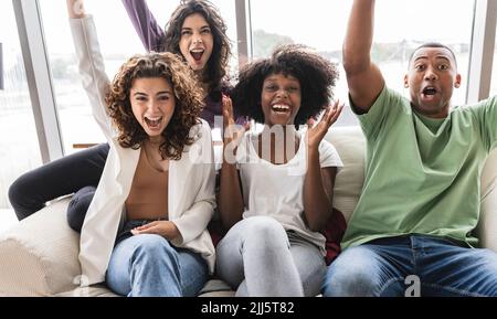 Cheerful friends having fun on sofa Stock Photo