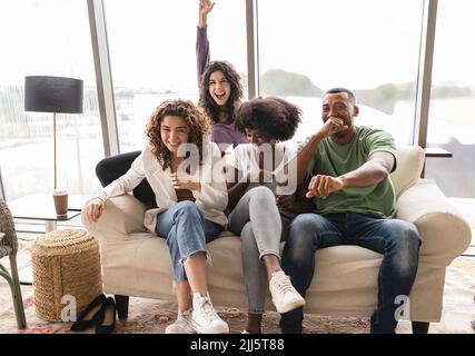 Cheerful friends having fun on sofa Stock Photo