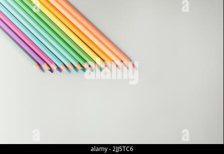 Studio shot of row of colored pencils lying against white background Stock Photo
