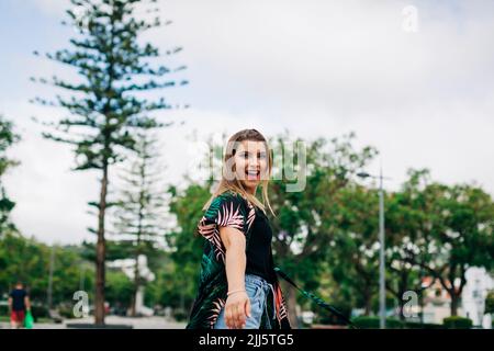 Cheerful young woman enjoying in park Stock Photo