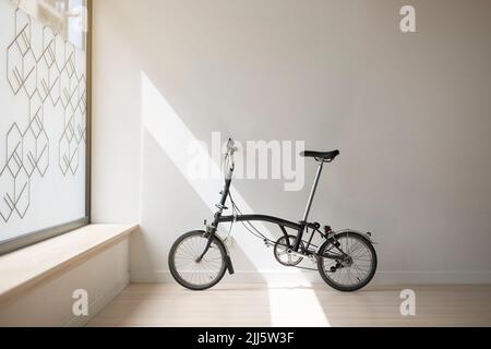 Bicycle leaning on white wall in yoga studio Stock Photo