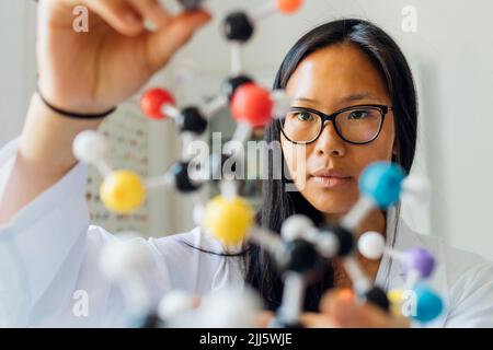 Scientist examining DNA model in laboratory Stock Photo