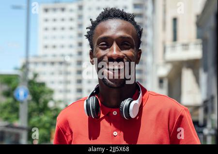 Happy man with wireless headphones on sunny day Stock Photo