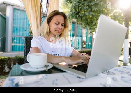 Smiling freelancer working on laptop Stock Photo