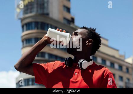Man drinking coffee from disposable cup on sunny day Stock Photo