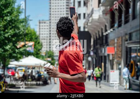 Man taking selfie through smart phone in city Stock Photo