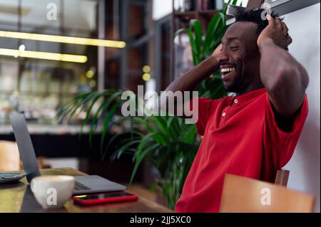Happy man with head in hands sitting at cafe Stock Photo