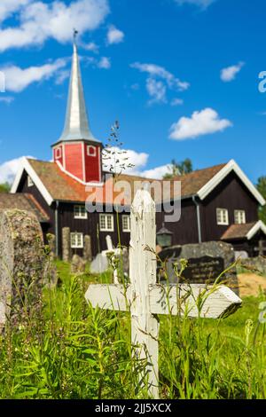 Norway, Viken, Flesberg, Medieval stave church in summer with graves in foreground Stock Photo