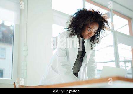 Female doctor using laptop at desk Stock Photo