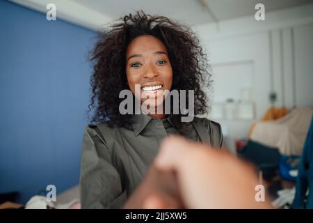 Happy businesswoman shaking hand with colleague in office Stock Photo