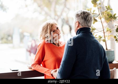 Smiling woman talking with man in cafe Stock Photo