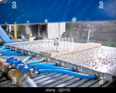CNC machine cutting wooden plank in factory Stock Photo