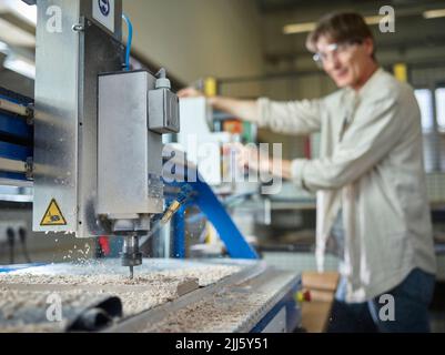 Carpenter milling with automated machinery in factory Stock Photo