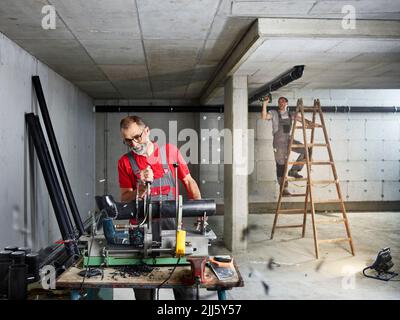 Plumbers installing pipes at construction site Stock Photo