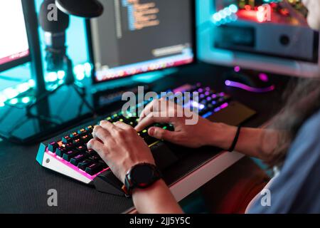 Man using keyboard in front of desktop PC at home Stock Photo