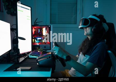 Man wearing VR glasses using steering wheel sitting at home Stock Photo