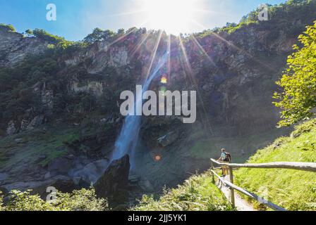 Senior man hiking near Foroglio waterfall on sunny day Stock Photo