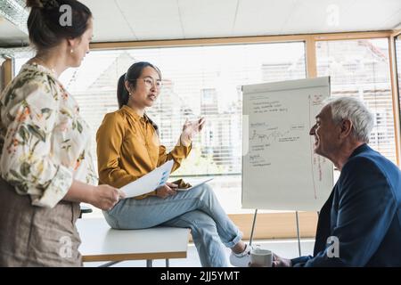 Multiracial business colleagues discussing work in office Stock Photo