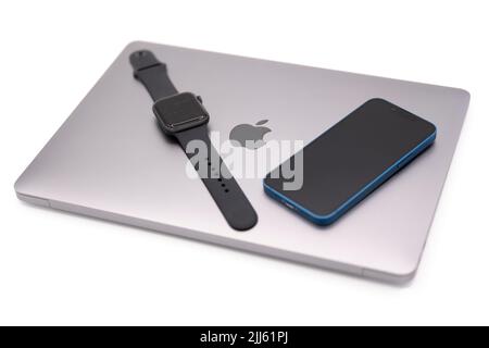 Apple products - MacBook Air laptop computer, Apple Watch smartwatch and Apple iPhone 13 Mini Stock Photo
