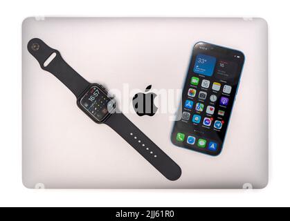 Apple products - MacBook Air laptop computer, Apple Watch smartwatch and Apple iPhone 13 Mini Stock Photo