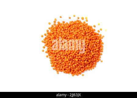 Dry red lentils on a white background isolate. Red lentil grits. Red lentils pile isolated. Dry orange lentil grains, heap of dal, raw daal, dhal Stock Photo