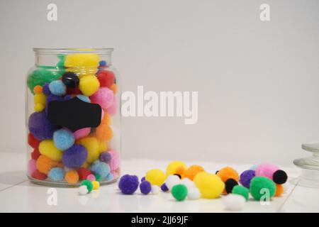 Colourful pom pom on a jar with background space for text. Background for art and crafts uses. Stock Photo