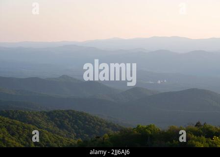 Looking down into the hazy West Virginian valleys during a summer evening where the 100 meter Green Bank Observatory can be seen in the distant valley Stock Photo