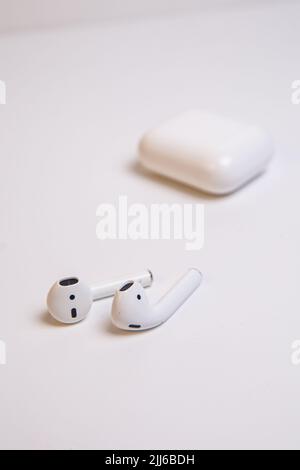 top view of white wireless headphones with a case on a white background. Stock Photo
